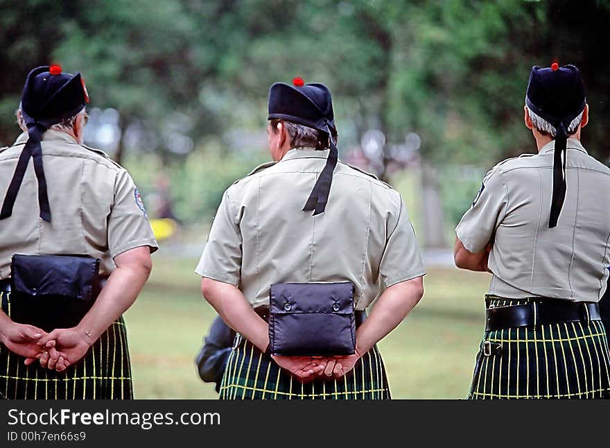 Three men wearing kilts