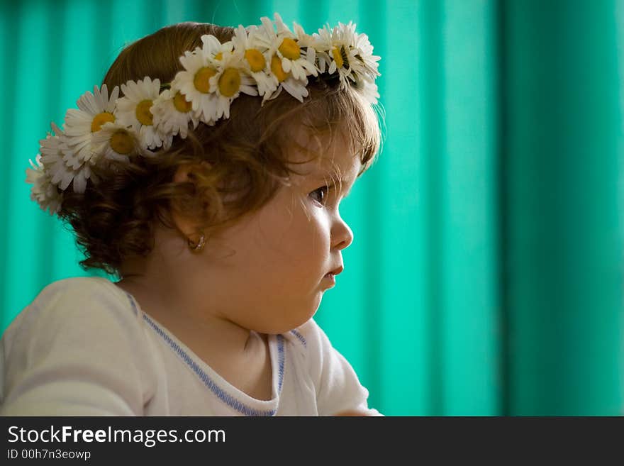 Portrait of a young girl gazing away in a thoughtful moment wearing a daisy crown - shallow depth of field - focus on the eye. Portrait of a young girl gazing away in a thoughtful moment wearing a daisy crown - shallow depth of field - focus on the eye