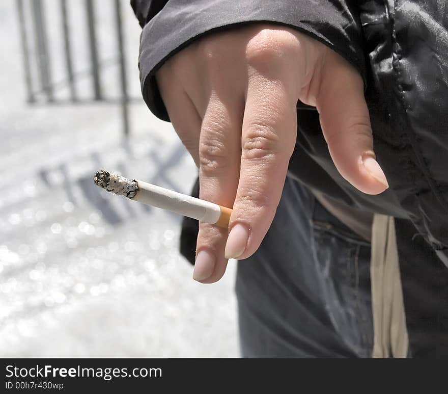 Smoking cigarette in woman`s hand