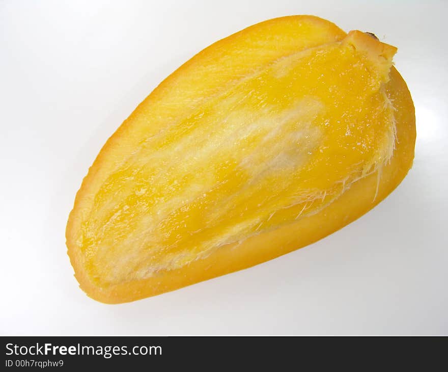 Sweet juicy champagne mango slice close-up with seed. Sweet juicy champagne mango slice close-up with seed