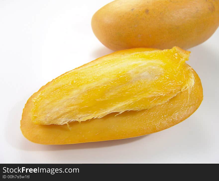 Sweet juicy champagne mango slice close-up with seed. Sweet juicy champagne mango slice close-up with seed