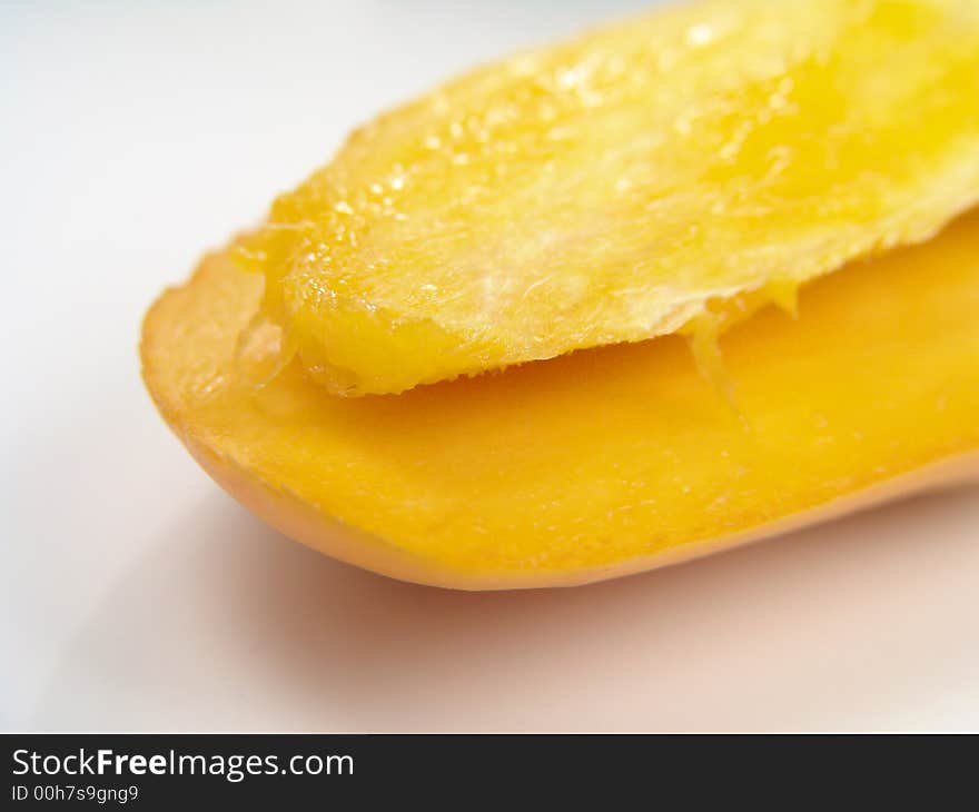 Sweet juicy champagne mango slice close-up with seed. Sweet juicy champagne mango slice close-up with seed