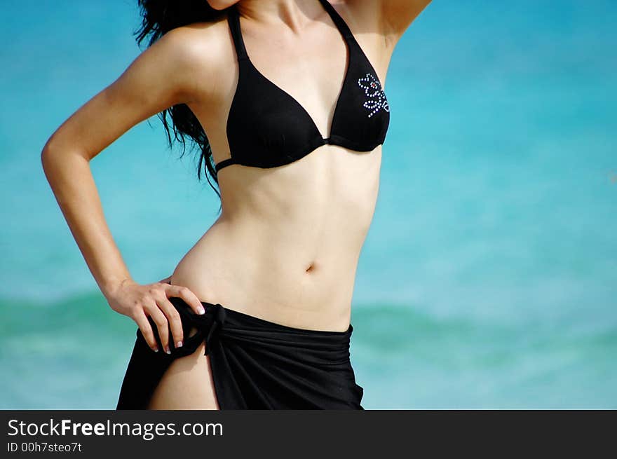 Young tropical girl wearing bikini on beach background. Young tropical girl wearing bikini on beach background