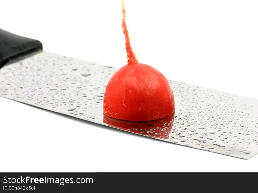 Part of a fresh radish on a wet cleaver's blade. Part of a fresh radish on a wet cleaver's blade