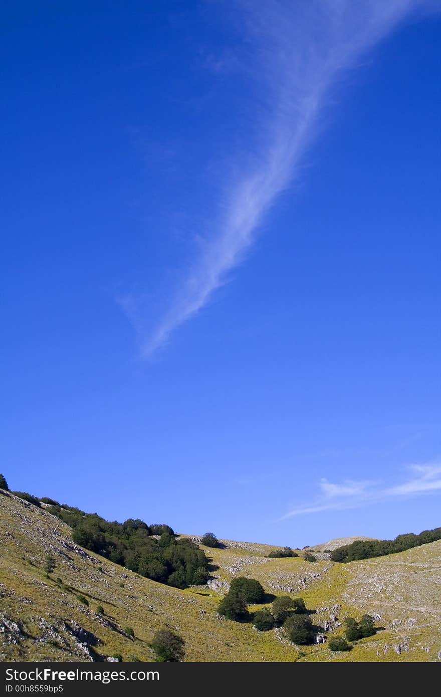 An isolated wake cloud in the blue sky. An isolated wake cloud in the blue sky.