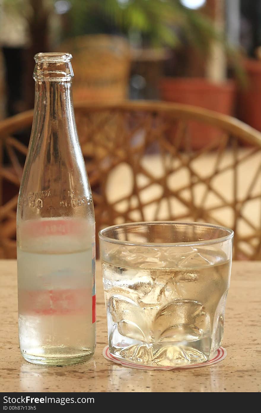 Glass of whiskey and bottle of water on a outdoor terrace. Glass of whiskey and bottle of water on a outdoor terrace