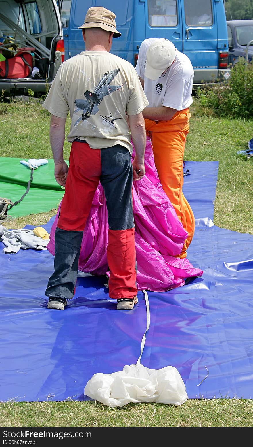 Two parachutists pack their equipment. Two parachutists pack their equipment