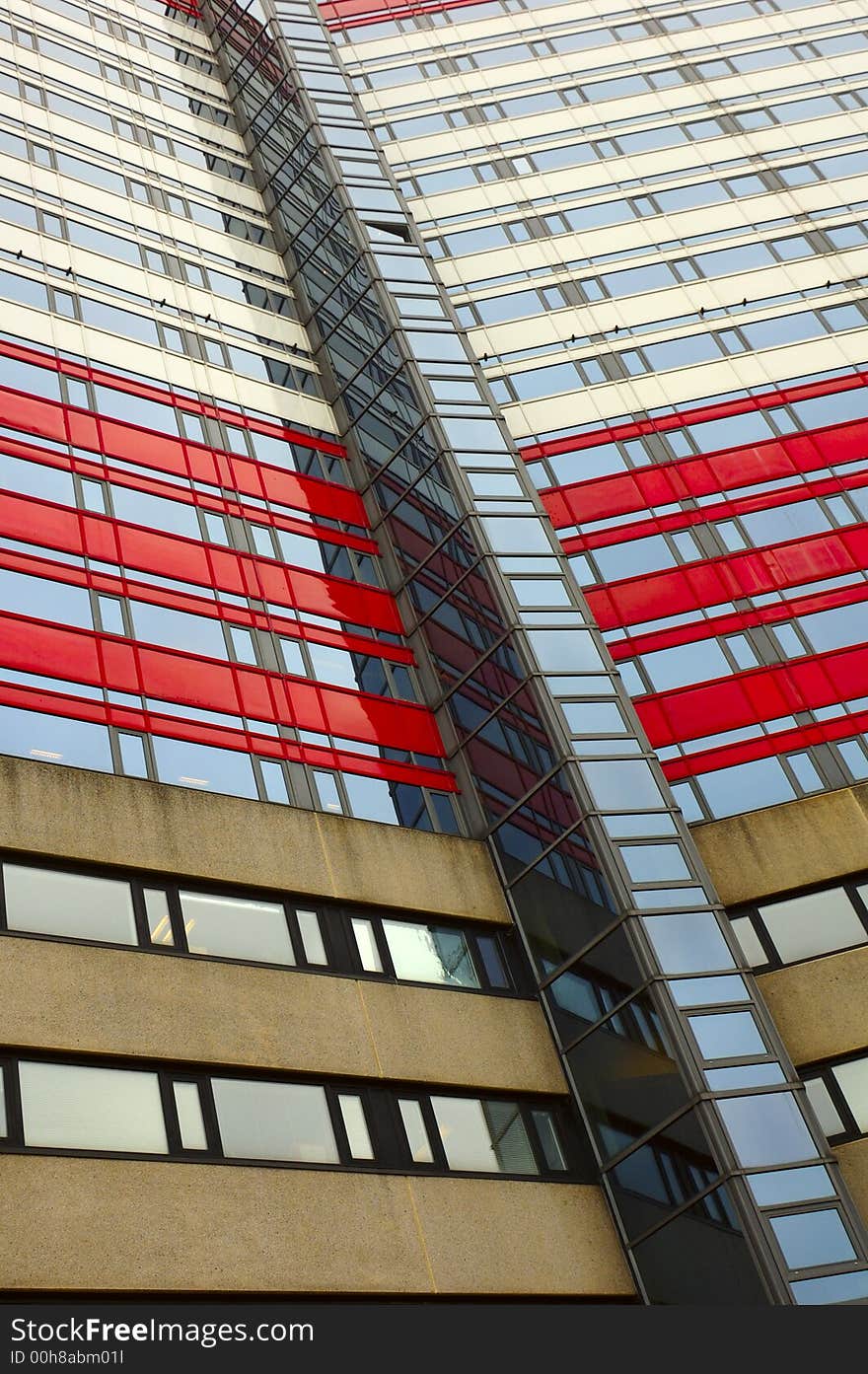 The side of a large, multi-colored office block with elevator shaft.