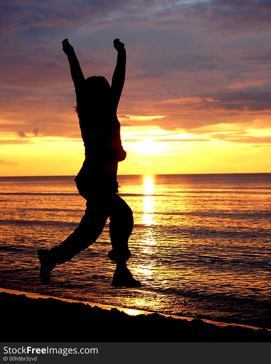 Woman jumping on the beach at sunrise. Woman jumping on the beach at sunrise