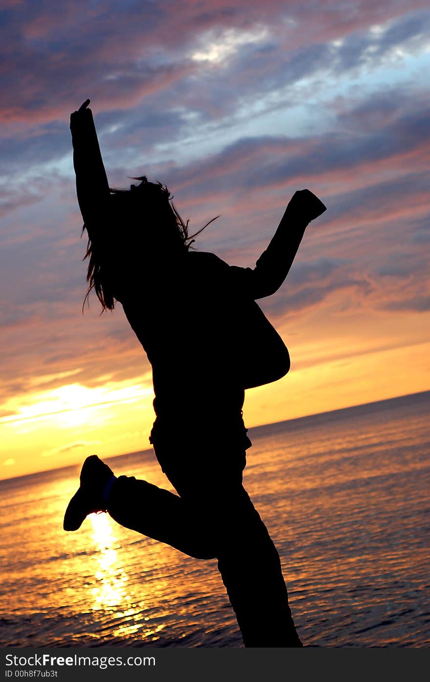 Woman jumping on the beach at sunrise. Woman jumping on the beach at sunrise