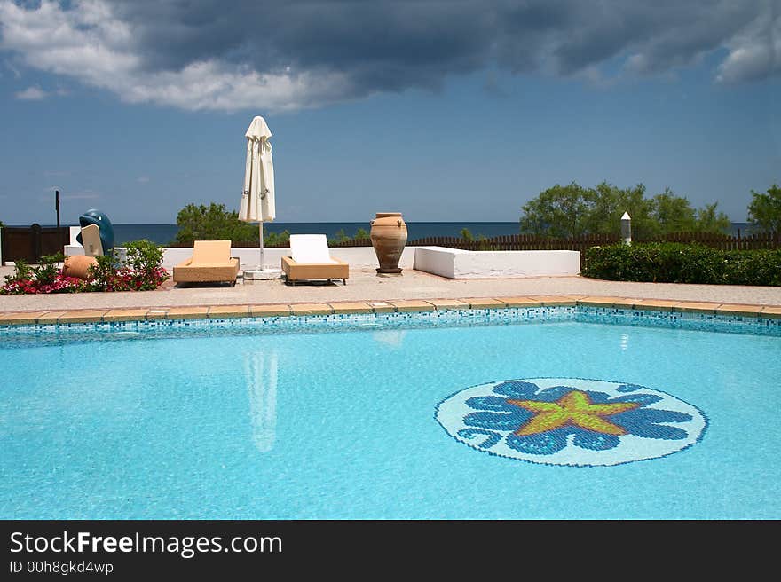 Swimming pool with sunshade on the seaside