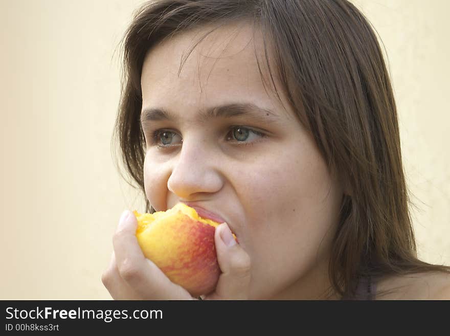 Young girl eating big juicy peach. Young girl eating big juicy peach