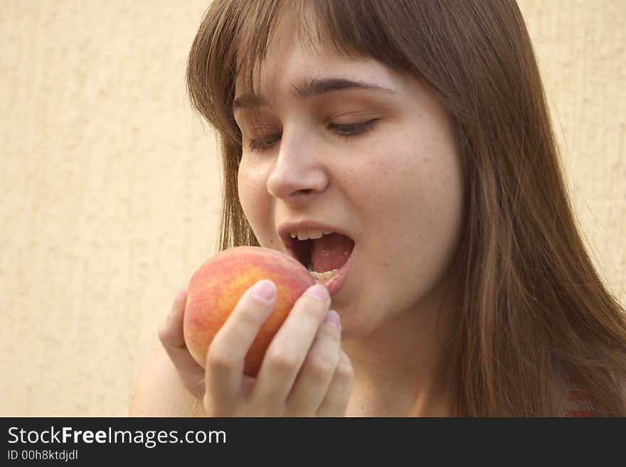 Young girl eating big juicy peach. Young girl eating big juicy peach