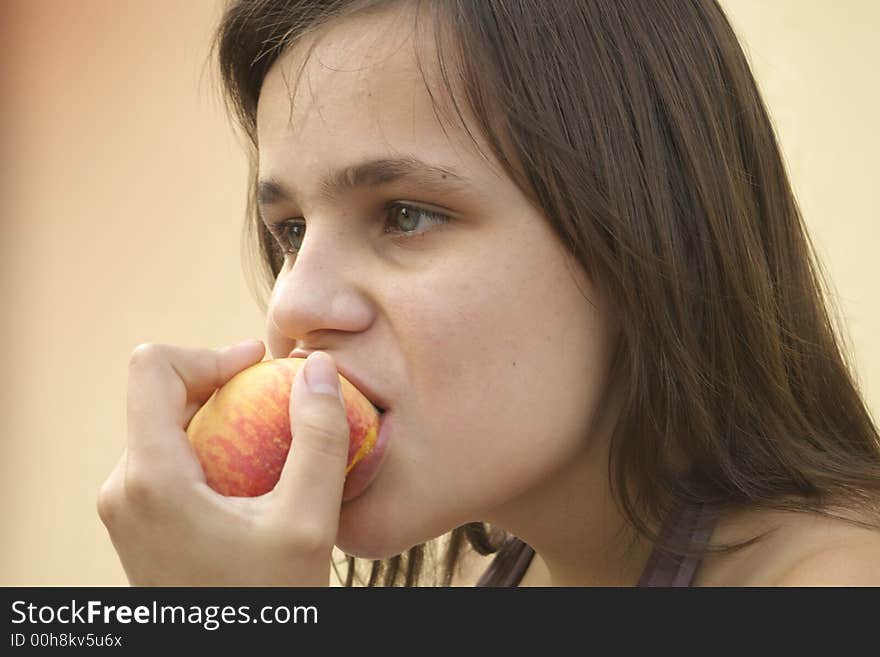 Girl eating big peach