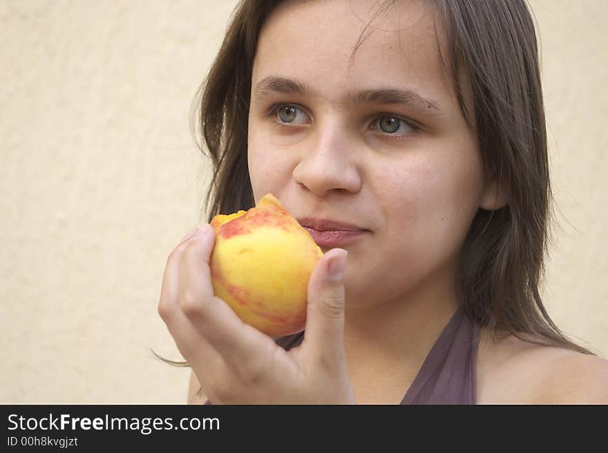 Girl eating big peach