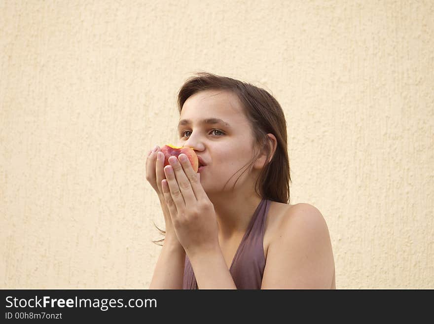 Girl eating big peach