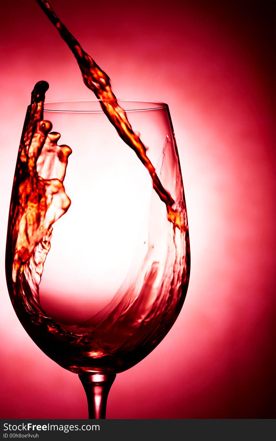 Close up view of wineglass getting filled with red wine. Close up view of wineglass getting filled with red wine