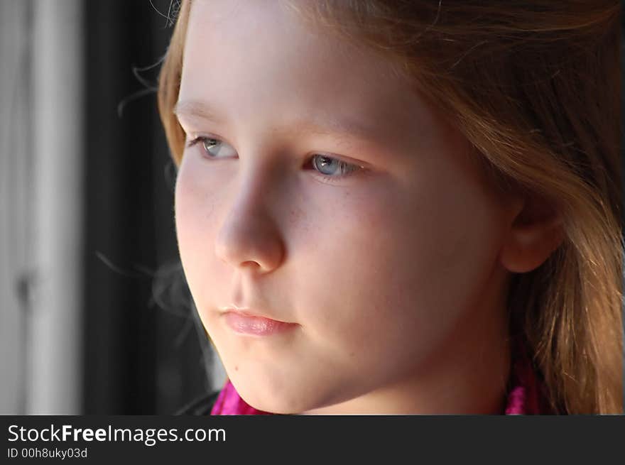 Young girl daydreaming out of window. Young girl daydreaming out of window