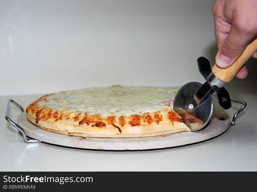 Chef cutting into a pizza. Chef cutting into a pizza