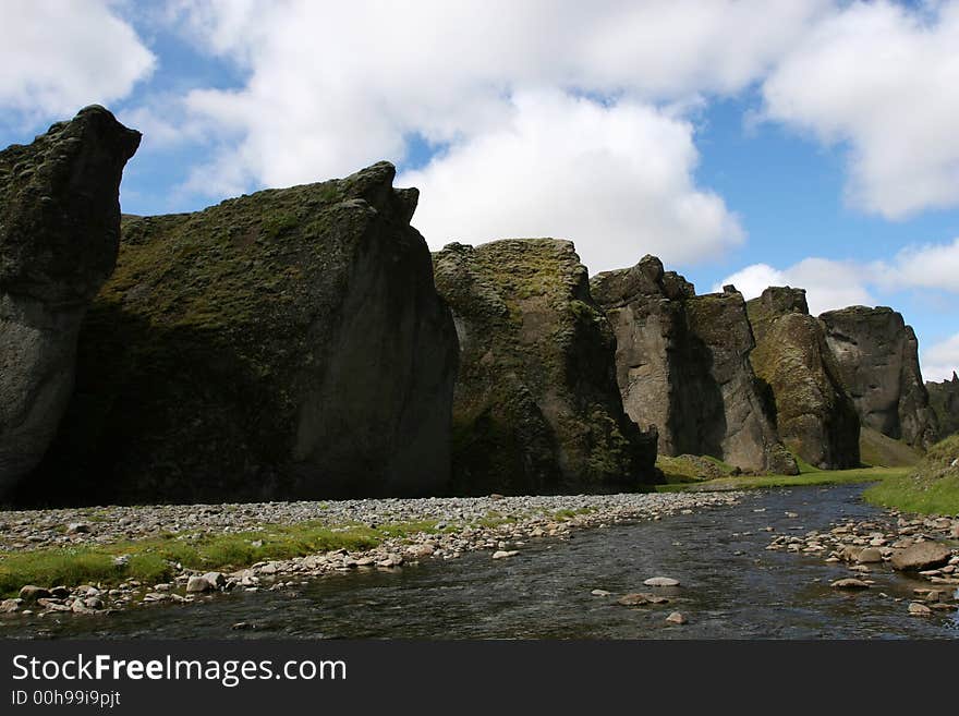 Magnificent scenic from inside a river canyon in southern Iceland, cliffs on all sides, and blue sky above. Magnificent scenic from inside a river canyon in southern Iceland, cliffs on all sides, and blue sky above