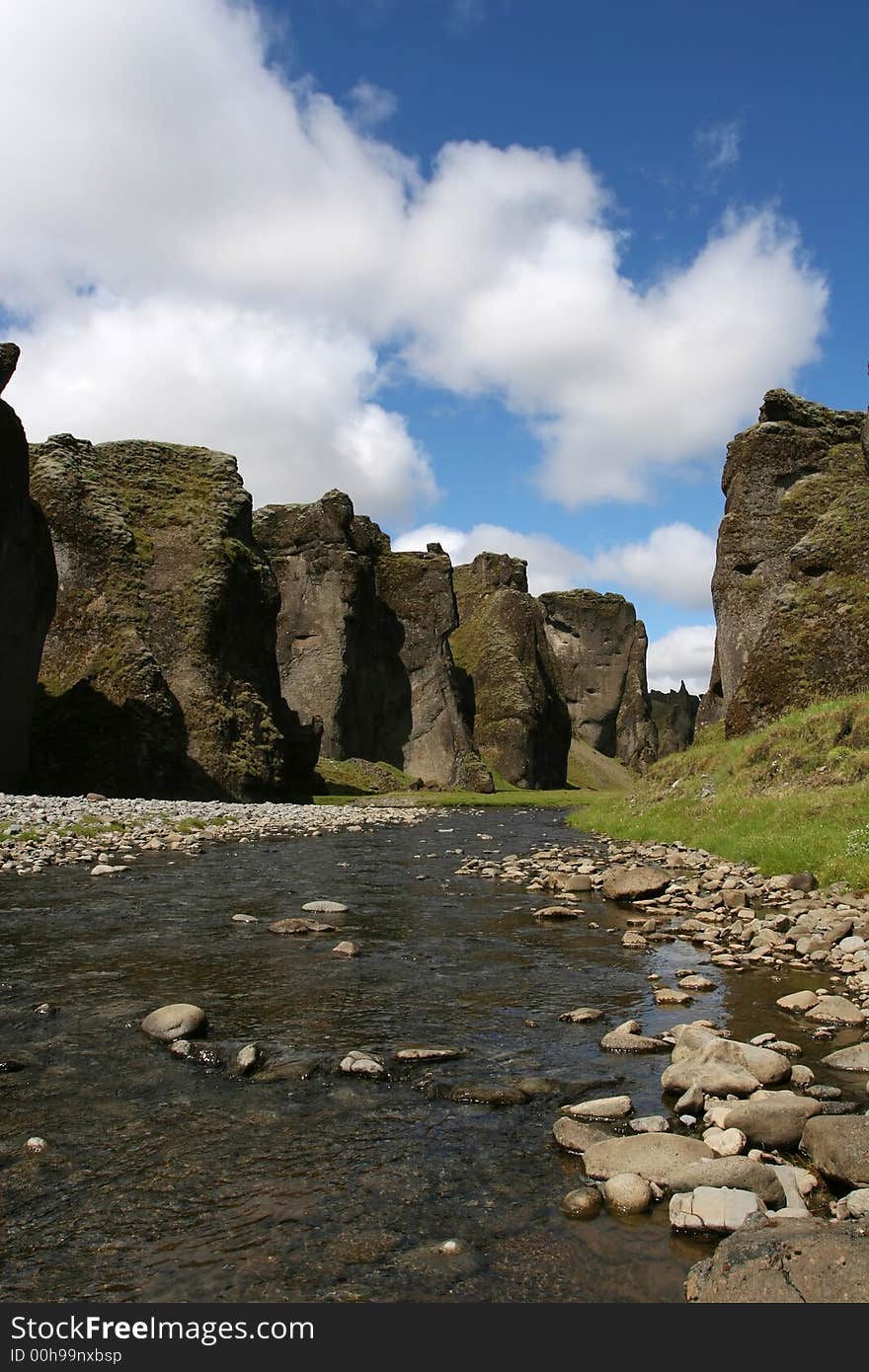 Magnificent scenic from inside a river canyon in southern Iceland, cliffs on all sides, and blue sky above. Magnificent scenic from inside a river canyon in southern Iceland, cliffs on all sides, and blue sky above