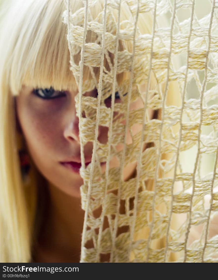 Blond woman s face behind net