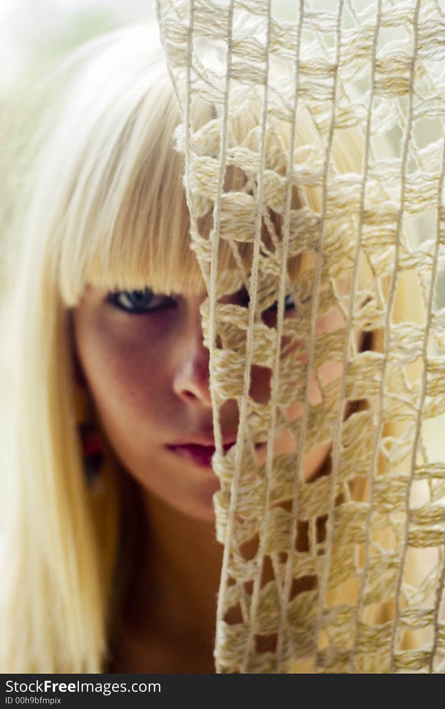 Blond woman s face behind net