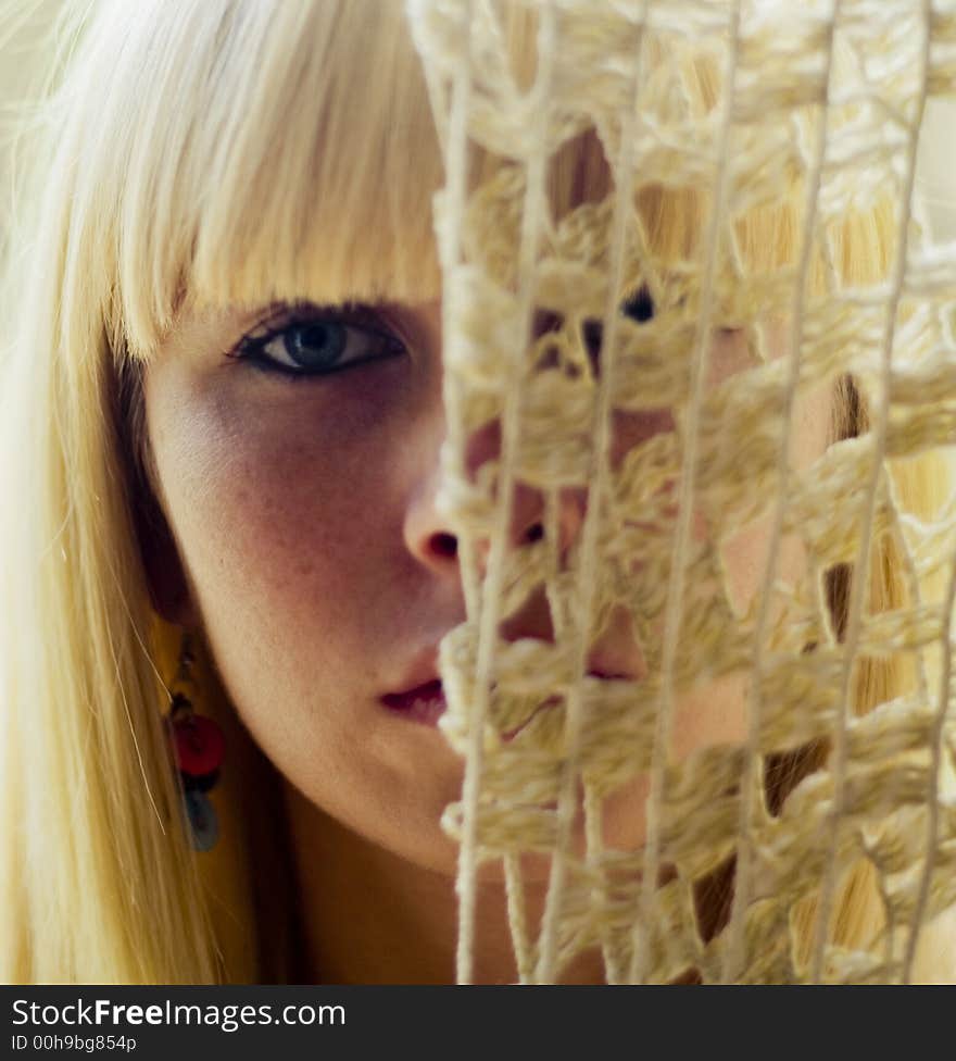 Blond woman s face behind net