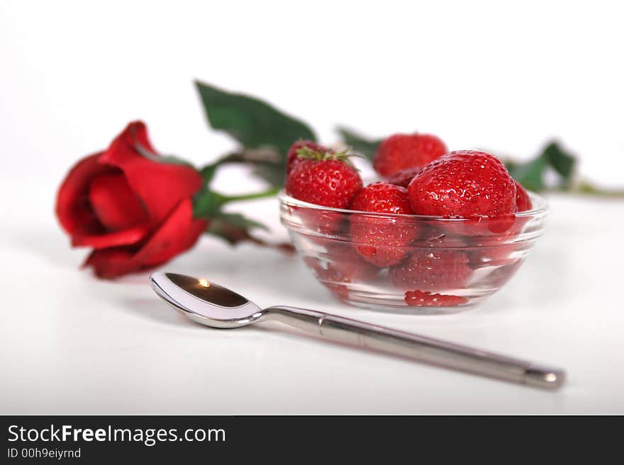 A fresh bowl of strawberries and a single red rose. A fresh bowl of strawberries and a single red rose.