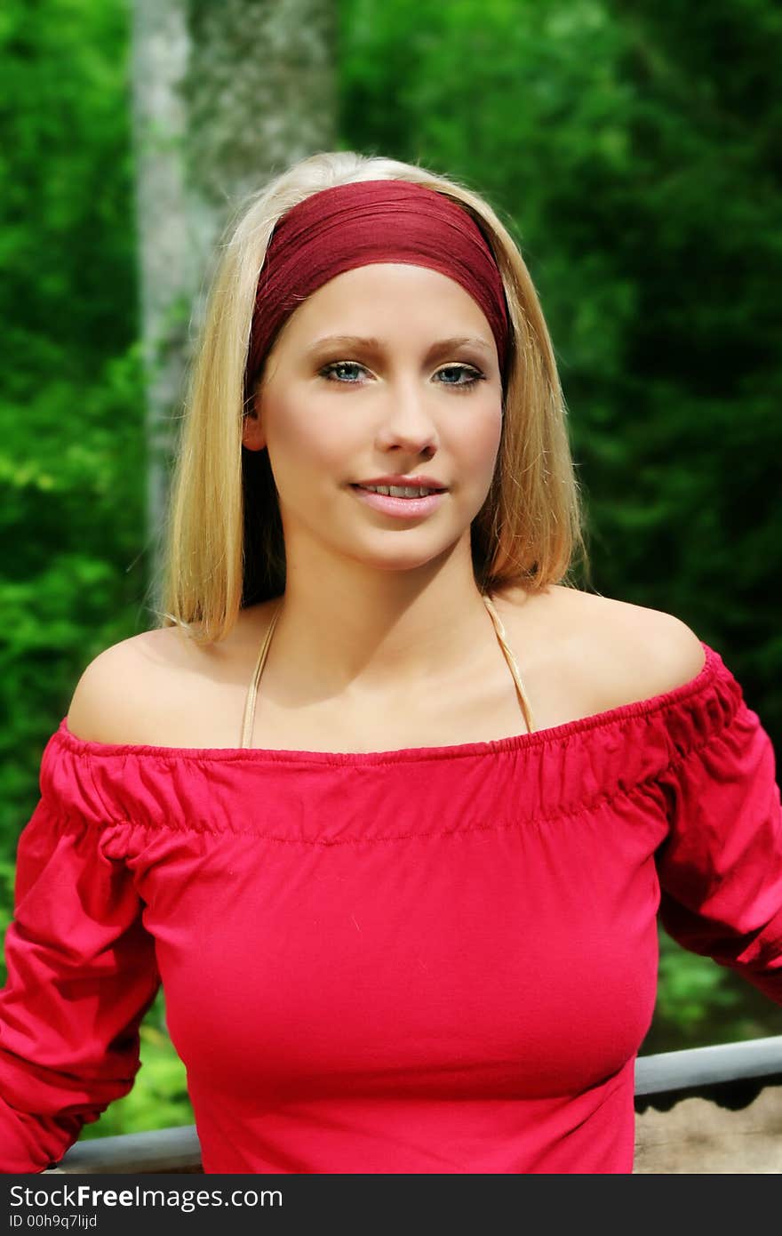 Outdoor beauty portrait of a young smiling woman in nature