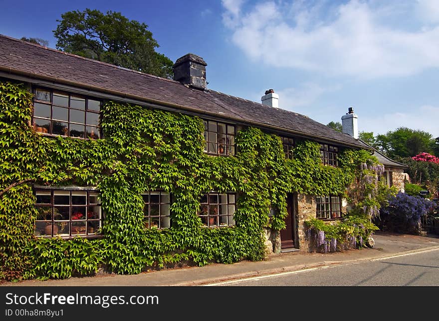 A country cottage, in rural Wales, under a spring sky.