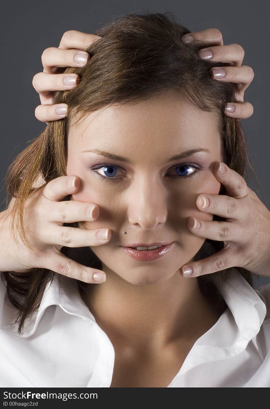 Attractive brunette with blue eyes and several hands on her face and head. Attractive brunette with blue eyes and several hands on her face and head