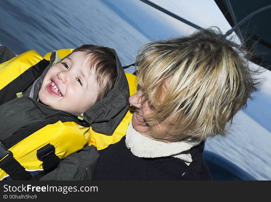 Baby with grandmother on a boat doing faces