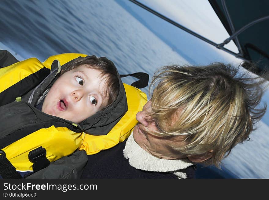 Baby with grandmother on a boat doing faces