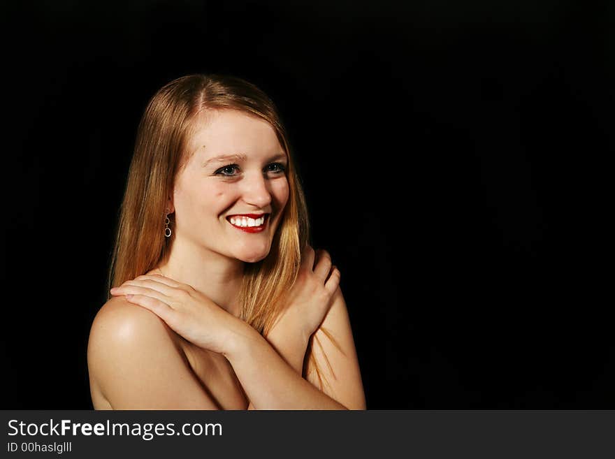 Beautiful blond woman smiling on a black background. Beautiful blond woman smiling on a black background