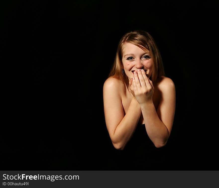 Beautiful blond woman smiling on a black background. Beautiful blond woman smiling on a black background