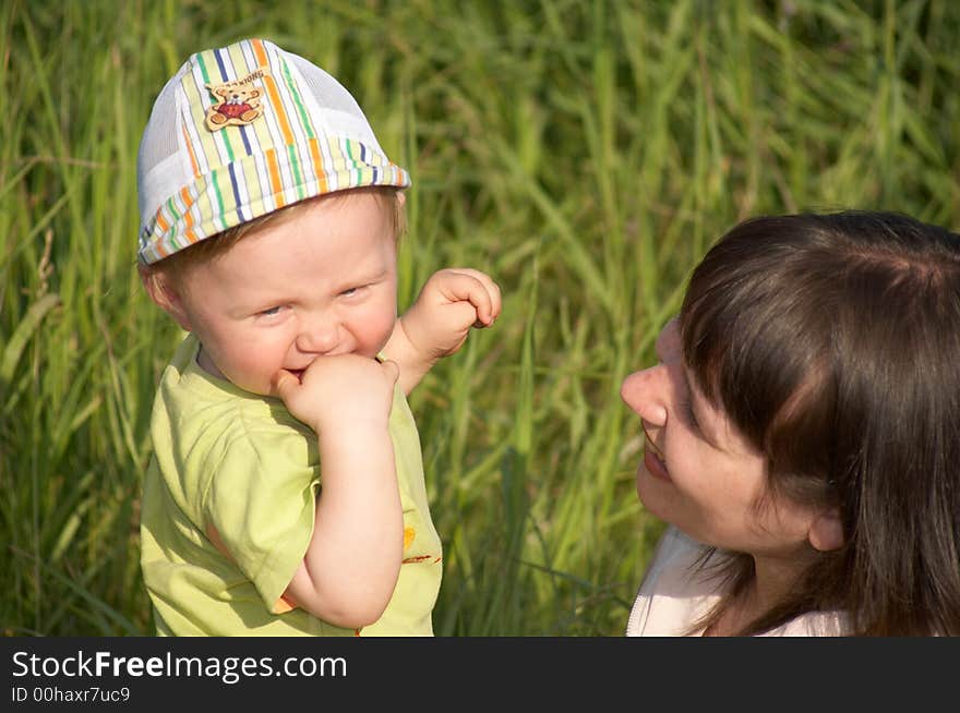 The happy mother plays with the son a background of a nature. The happy mother plays with the son a background of a nature