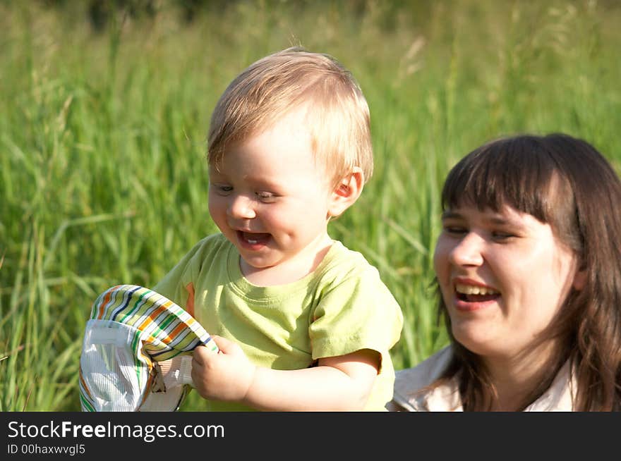 The happy mother plays with the son a background of a nature. The happy mother plays with the son a background of a nature