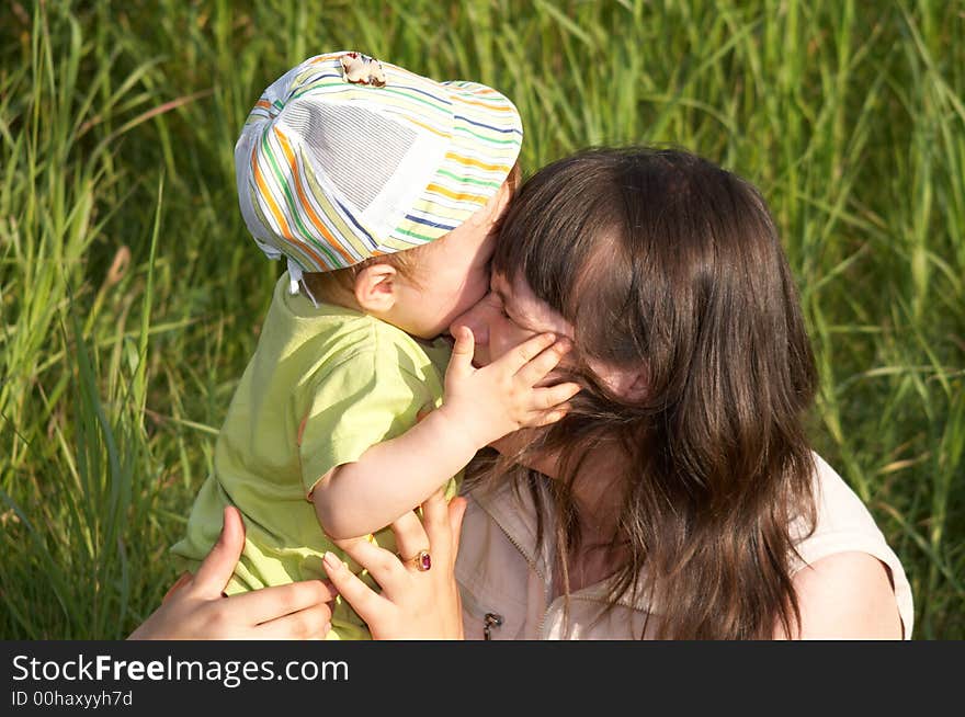 The child embraces the mum a background of a nature. The child embraces the mum a background of a nature