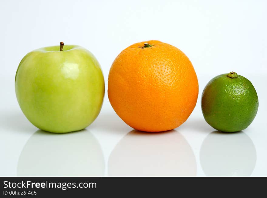 An apple, orange and lime in a row. An apple, orange and lime in a row