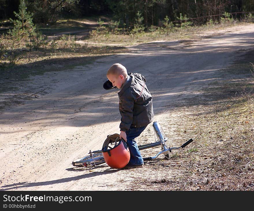 The boy goes for a drive on a bicycle in a fatherly motorcycle helmet. The boy goes for a drive on a bicycle in a fatherly motorcycle helmet