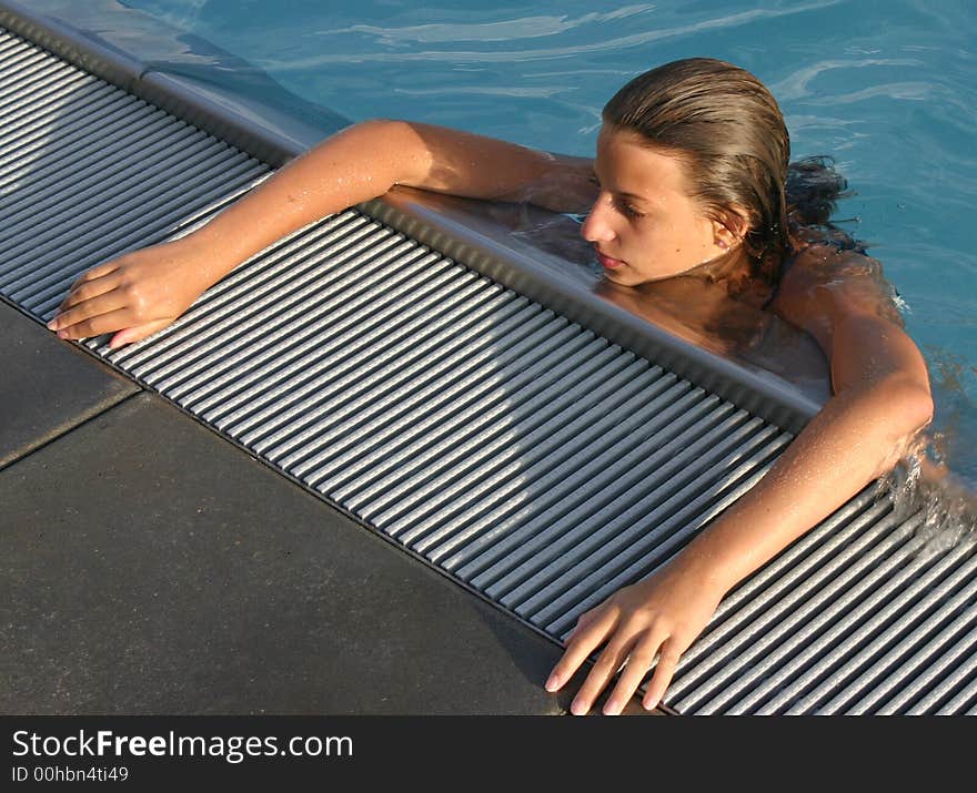 Girl leaning on the outskirts pool. Girl leaning on the outskirts pool