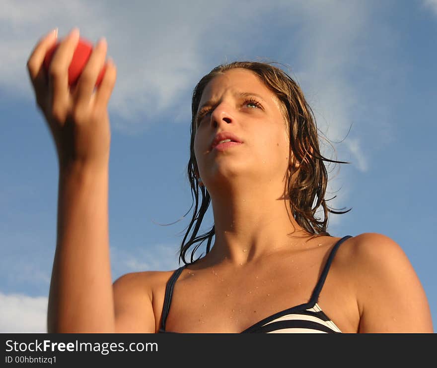 Girl in swimsuit juggling with the red ball. Girl in swimsuit juggling with the red ball