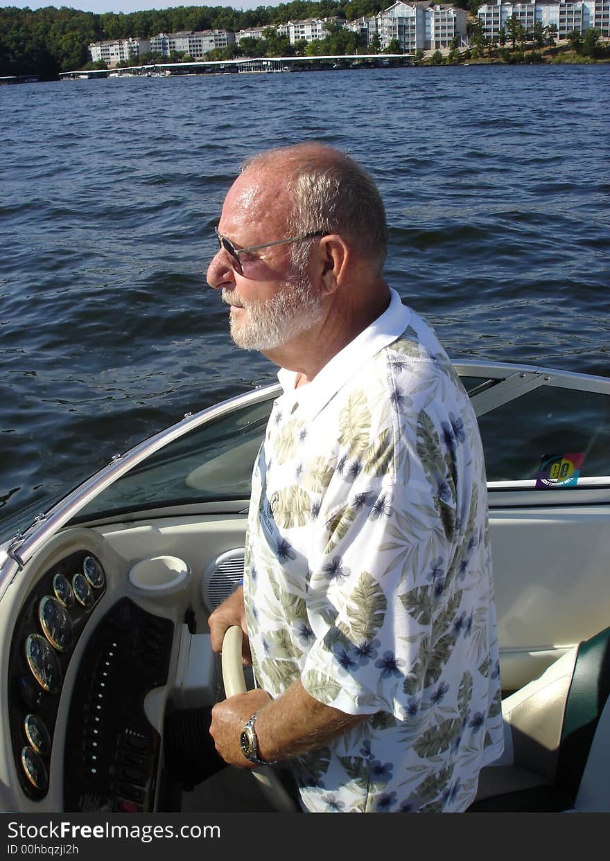 Senior man enjoying driving his boat. Senior man enjoying driving his boat.