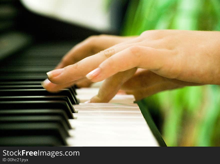 A closeup of a pair of hands playing a piano. A closeup of a pair of hands playing a piano.