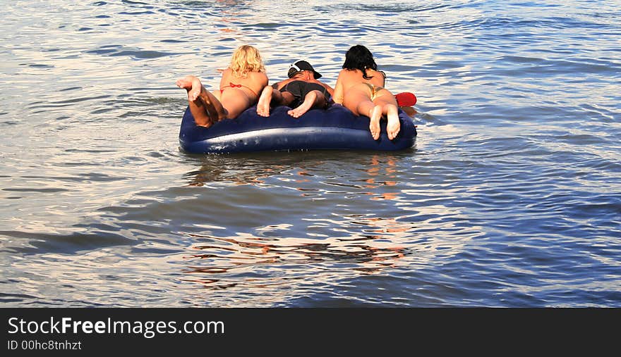 On a photo people are represented floating on a water mattress. On a photo people are represented floating on a water mattress