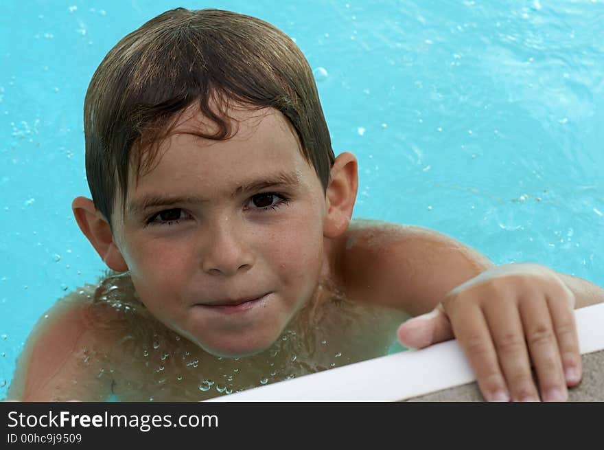 Young boy smiling in pool water. Young boy smiling in pool water