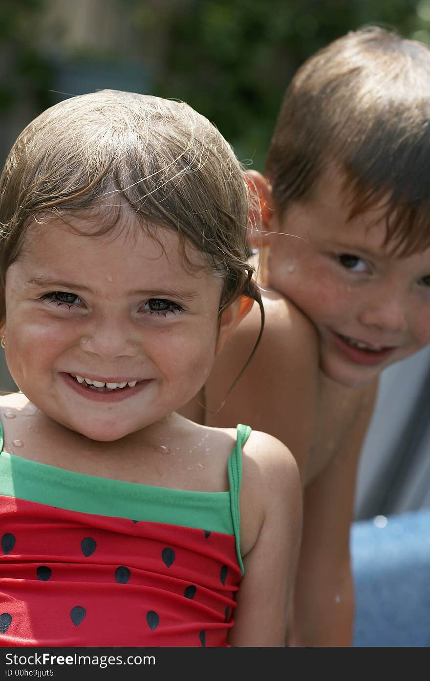 Young girl and boy smiling in pool water. Young girl and boy smiling in pool water