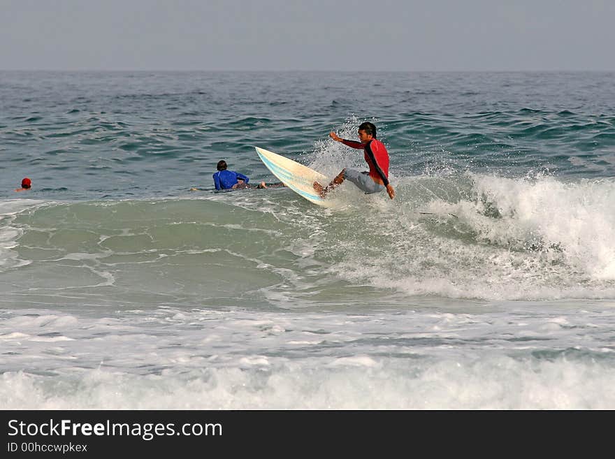 A local surfer hits the top of a wave in the tropical resort of Phuket, Thailand. A local surfer hits the top of a wave in the tropical resort of Phuket, Thailand