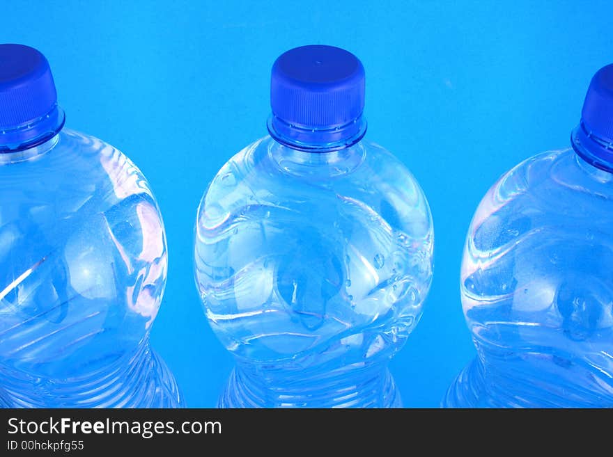 Mineral water pouring from a blue bottle